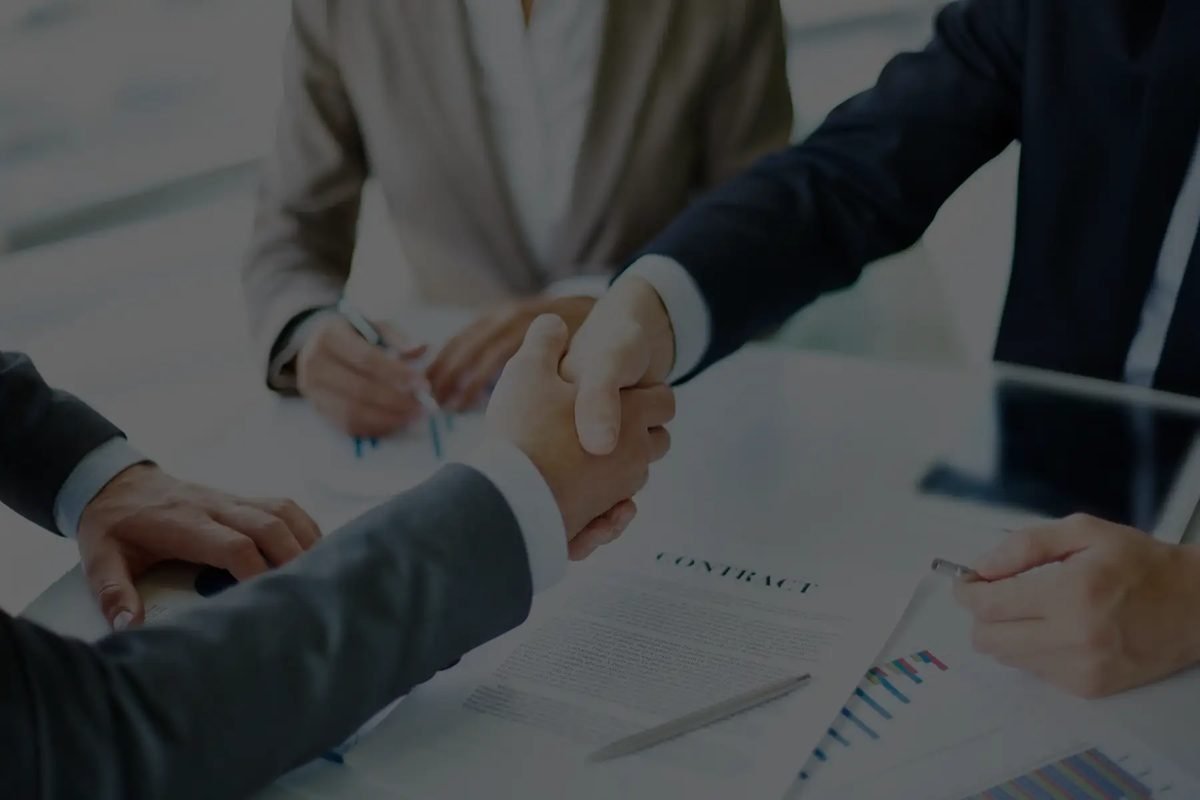 Two people shaking hands over a franchise agreement